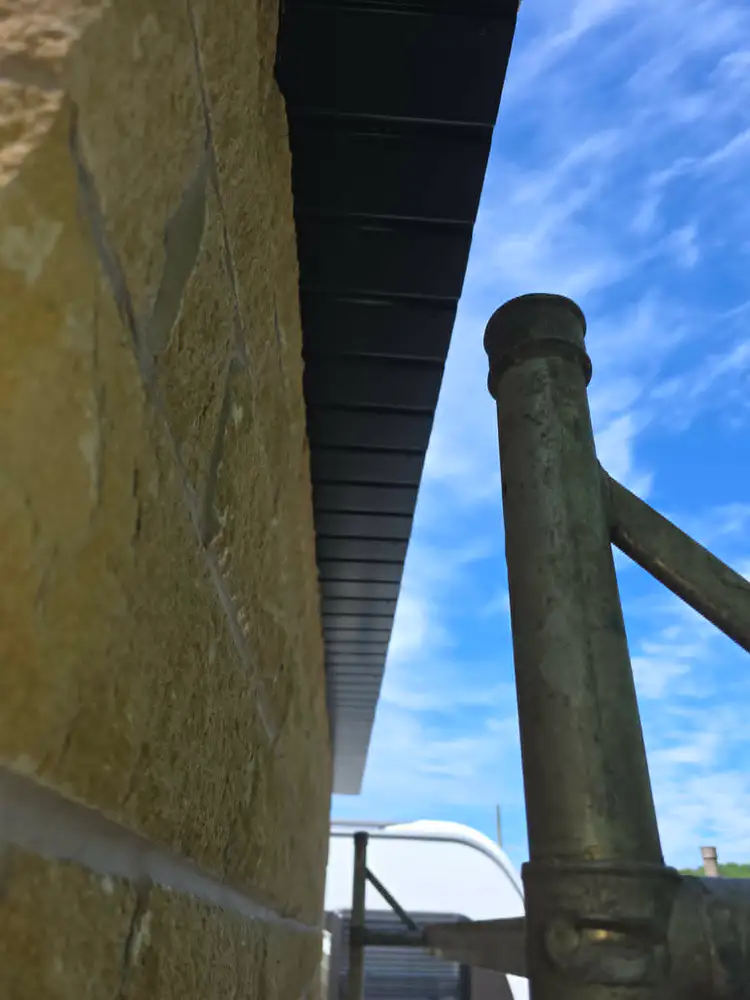 Black roofline on stone property by Kings Roofing